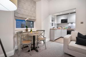 a kitchen and living room with a table and a couch at One Merewyke in Bowness-on-Windermere