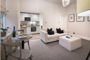 a living room with a couch and a table at Courtyard Apartments in Bowness-on-Windermere