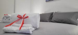 a pile of towels with a red ribbon on a bed at Erre Home in Naples