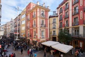 Eine Menschenmenge, die eine Straße mit Gebäuden entlangläuft. in der Unterkunft Lovely Apartments - Increíble loft en el corazón de Madrid in Madrid
