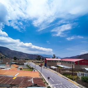 a city with a red building and mountains in the background at Apartamento Colca 's Home, cuenta con dos habitaciones in Chivay