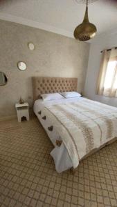 um quarto com uma cama grande e uma janela em Riad D’AR GANne by Carole em Essaouira