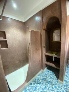 a bathroom with a shower with a sink and a mirror at Riad D’AR GANne by Carole in Essaouira