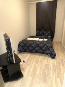 a bedroom with a bed and a desk with a television at Ade 1 in Oulu