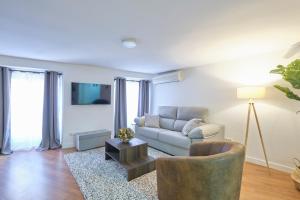 a living room with a couch and a table at Lovely Apartments - Increíble loft en el corazón de Madrid in Madrid