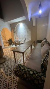 salon ze stołem i kanapą w obiekcie Riad D’AR GANne by Carole w mieście As-Suwajra