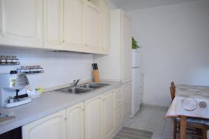 a kitchen with white cabinets and a sink at La Casa del Carrubo in Cagliari