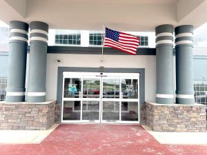 an american flag flying over the front door of a building at Super 8 by Wyndham San Antonio/Alamodome Area in San Antonio