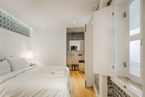 a white bedroom with a bed and a window at Deco Gem in Santa Catarina in Lisbon