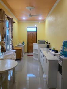 a large kitchen with white counters and a door at Maavaharu - K.Huraa in Huraa