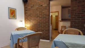 uma sala de jantar com mesa e cadeiras e uma parede de tijolos em Pension Britta em Roetgen
