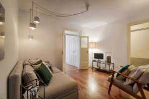 a living room with a couch and a television at Romantic Gem in Santos in Lisbon