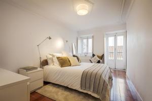 um quarto branco com uma cama e um candeeiro em Romantic Gem in Santos em Lisboa