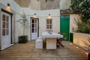 a patio with a white table and a green door at Romantic Gem in Santos in Lisbon