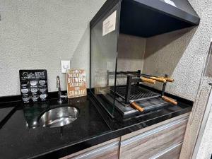 encimera con fregadero y espejo en Apartamento 105 em condomínio de alto padrão, en Guarulhos
