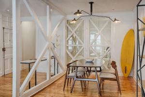 a dining room with a table and chairs and surfboards at Architectural Gem in Bica in Lisbon