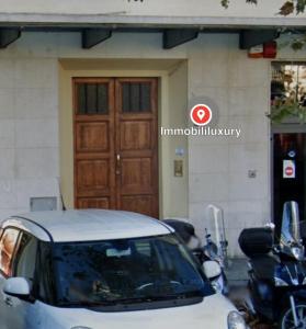 un coche aparcado frente a un edificio con una puerta en Beccaria - Florence luxury Apartment, en Florencia