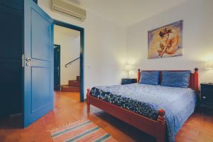 a bedroom with a bed and a blue door at Vila Mourisca in Armação de Pêra