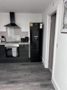 a kitchen with a black refrigerator and a stove at Home in Leicester! in Leicester
