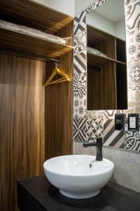 La salle de bains est pourvue d'un lavabo blanc et d'un miroir. dans l'établissement HOTEL DEL CARMEN, à Zitácuaro