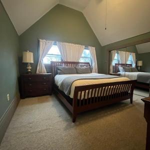 1 dormitorio con 1 cama grande y espejo grande en Stone Gables Inn, en Cleveland