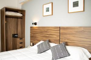 - une chambre avec un lit blanc et une tête de lit en bois dans l'établissement HOTEL DEL CARMEN, à Zitácuaro