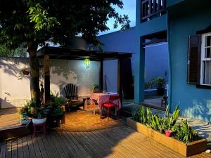 un patio con mesa y sillas y un edificio en Solar das Pétalas Guest House, en Florianópolis