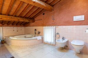 a bathroom with a tub and a toilet and a sink at Al Cantico in Mason Vicento