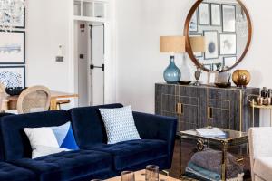 uma sala de estar com um sofá azul e um espelho em Master Deco Gem in Baixa em Lisboa
