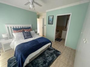 a bedroom with a large bed with blue walls at Oceanic Breeze in Margate