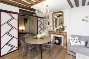 - un salon avec une table et une cheminée dans l'établissement My Nest Inn Paris Panthéon - 31m2 - 2min du Panthéon, à Paris