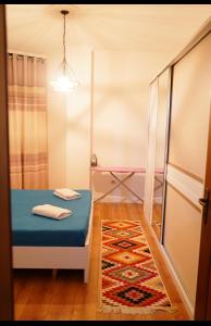 um pequeno quarto com uma cama e um tapete em Apartament Center Tirana em Tirana
