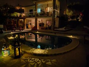 a swimming pool in front of a house at night at Au Jardin d'Armand in Sant Pere de Ribes