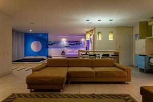 uma sala de estar com um sofá e uma sala de jantar em Nantai premium MOTEL em Florianópolis