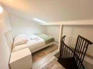 a small bedroom with a bed and a staircase at L'Horizon - Superbe appartement entre Paris & Disney in Gagny