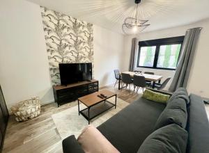 a living room with a couch and a table at L'Horizon - Superbe appartement entre Paris & Disney in Gagny