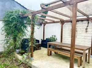 a wooden bench sitting under a wooden pergola at L'Horizon - Superbe appartement entre Paris & Disney in Gagny