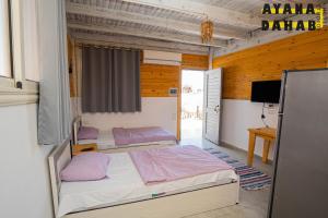 a bedroom with two beds and a television in it at Ayana Hotel Dahab in Dahab