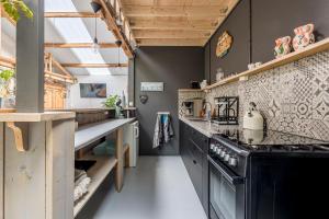 una cucina con piano cottura nero e bancone di Het Kamphuis, landelijk slapen a Heerhugowaard