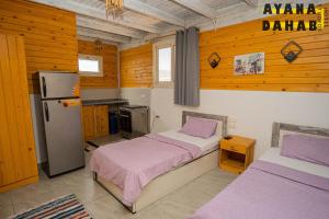 a bedroom with two beds and a refrigerator at Ayana Hotel Dahab in Dahab