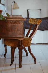 an old wooden desk with a chair and a bed at Axatorpsgården in Trelleborg