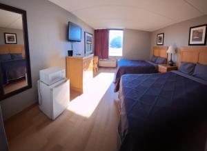 una camera d'albergo con due letti e una televisione di Madison Inn & Suites a Madison