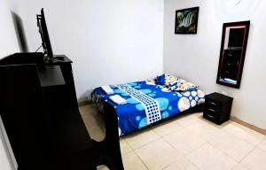 - une chambre avec un lit et une télévision à écran plat dans l'établissement Tu hogar lejos de casa., à Garzón