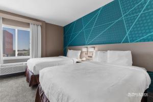 Un pat sau paturi într-o cameră la AmeriK Suites Laredo Behind Mall Del Norte