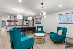 a living room with blue chairs and a table at AmeriK Suites Laredo Behind Mall Del Norte in Laredo