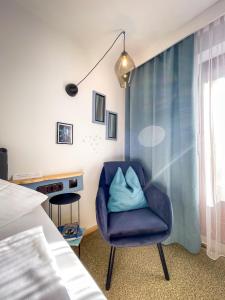 Una silla azul en un dormitorio con cama en Hotel Tenne, en Sankt Anton am Arlberg
