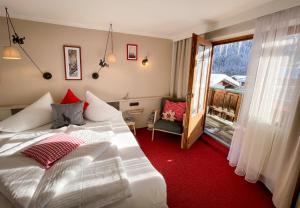 a bedroom with a white bed and a window at Hotel Tenne in Sankt Anton am Arlberg