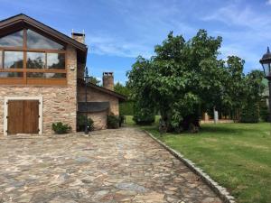 Casa Do Rivera في Cospeito: منزل به شجرة وممر حجري