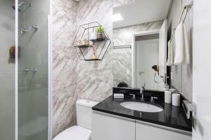 a bathroom with a sink and a toilet and a mirror at 0909 - Refugio Bosque Maia in Guarulhos +13 photos