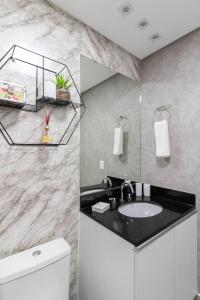 a bathroom with a sink and a mirror at Apartamento 909 em condomínio de alto padrão in Guarulhos